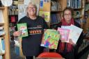 Paula Blake collects a donation from Newham Bookshop's Vivian Archer