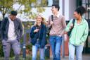 Group Of University Students Outdoors Walking Past College Buildings