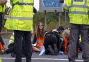 Police work to free protesters who had glued themselves to a slip road of the A1(M)