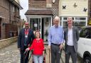 Trevor and Doreen Lock with councillors Peter Chand and Dominic Twomey outside their home, with the plaque in their honour visible above the door.