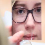 A young women taking a lateral flow test