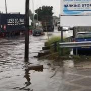 Vehicles driving through flood water in Renwick Road.