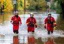 Firefighters walk through floodwaters while responding to a rescue call in Sonoma County, California (AP Photo/Noah Berger)