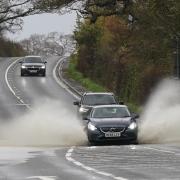 A vehicle is driven through floodwater after heavy rain in Shipston-on-Sour in Warwickshire (Jacob King/PA)