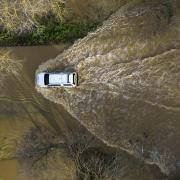 A car drives through floodwater at the Billing Aquadrome in Northamptonshire (Jordan Pettitt/PA)